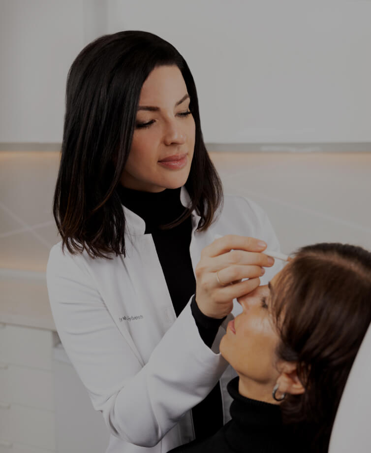 Dr. Chloé Sylvestre doing markings in preparation of a neuromodulator injection treatment on the forehead of a female patient