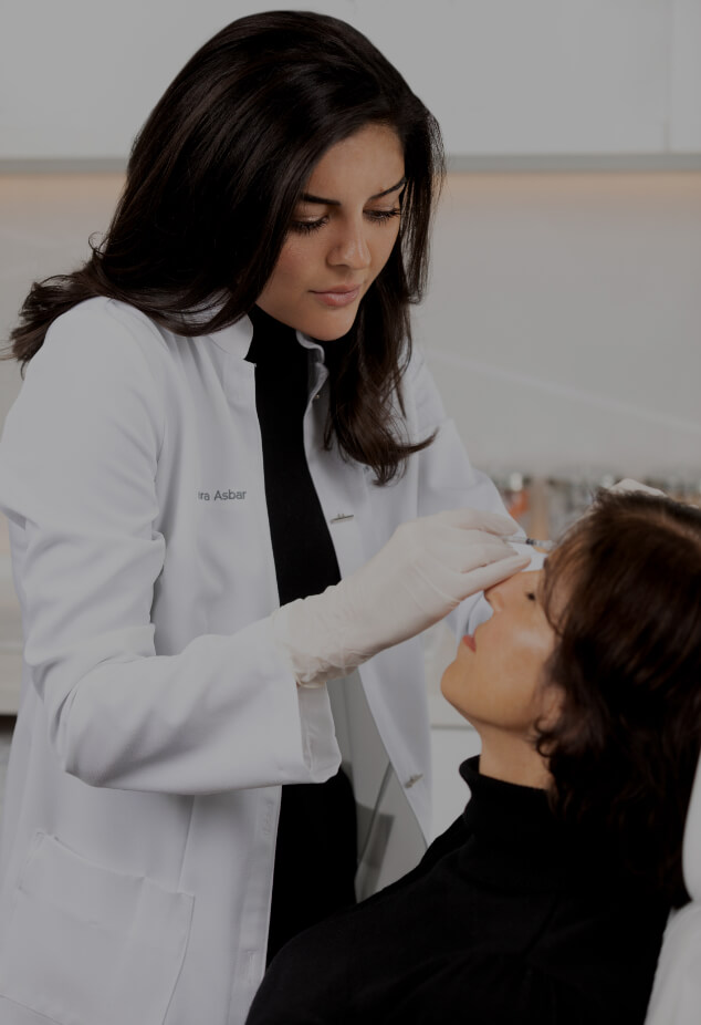 Dr. Yara Asbar performing neuromodulator injections in the forehead of a female patient