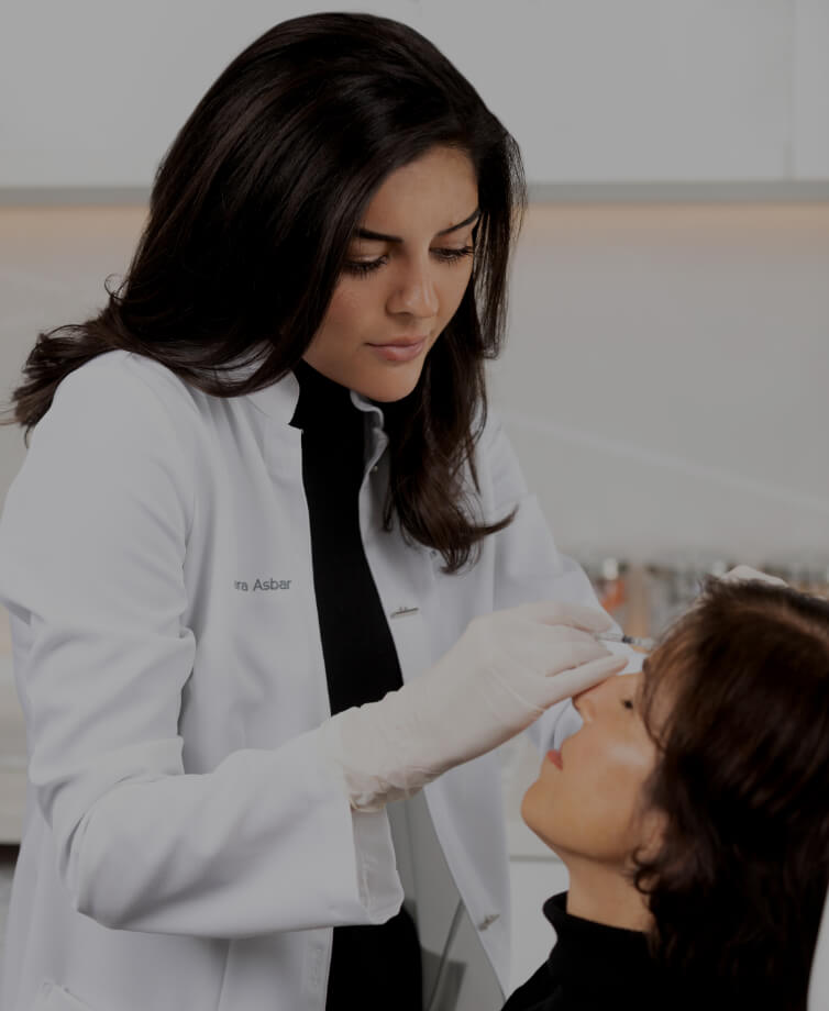 Dr. Yara Asbar performing neuromodulator injections in the forehead of a female patient