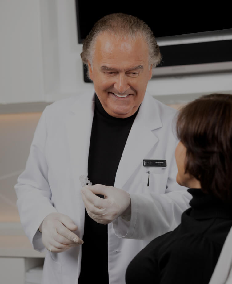Dr Pierre Rochon, dentiste, expliquant et démontrant à sa patiente comment employer les aligneurs Invisalign