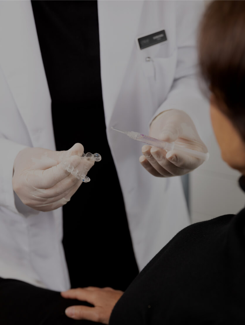 Le dentiste de la Clinique Chloé expliquant le fonctionnement du blanchiment dentaire à une patiente