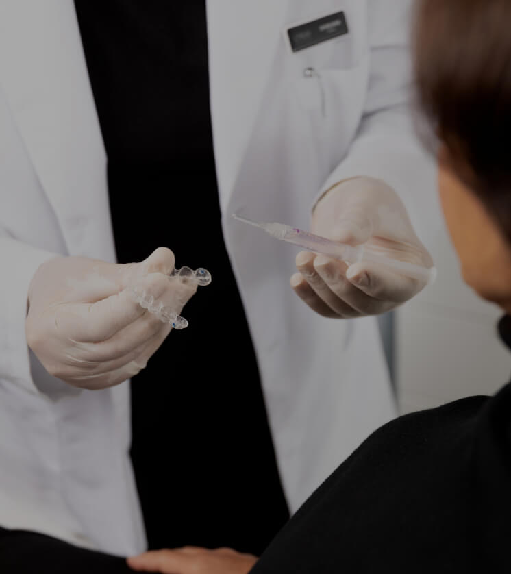 Le dentiste de la Clinique Chloé expliquant le fonctionnement du blanchiment dentaire à une patiente