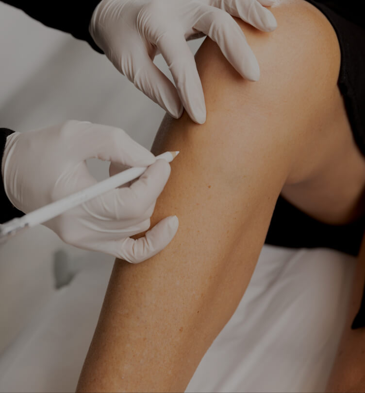 Une technicienne médico-esthétique de la Clinique Chloé délimitant les zones à épiler au laser sur les jambes d'une femme