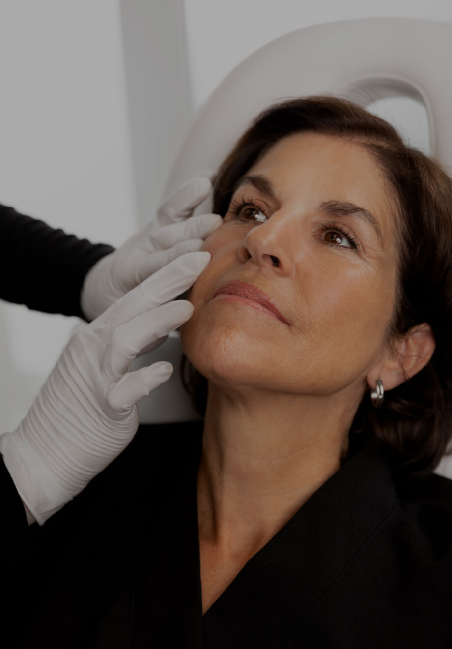 Une technicienne médico-esthétique de la Clinique Chloé pratiquant un examen visuel des manifestations d'acné d'une patiente
