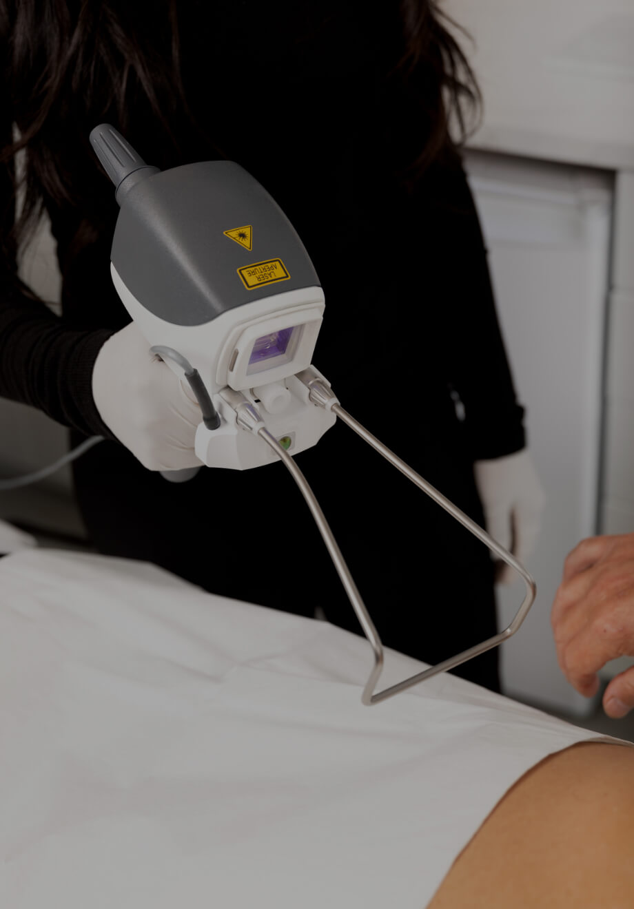 Une technicienne médico-esthétique de la Clinique Chloé tenant la pièce à main laser Hot Sculpting devant une patiente
