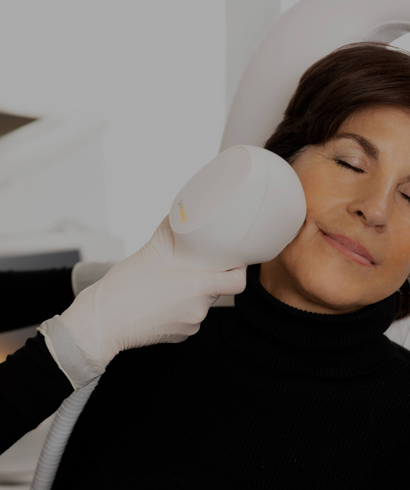 Une technicienne de la Clinique Chloé traitant le visage d'une patiente à l'aide d'un appareil de lumière intense pulsée