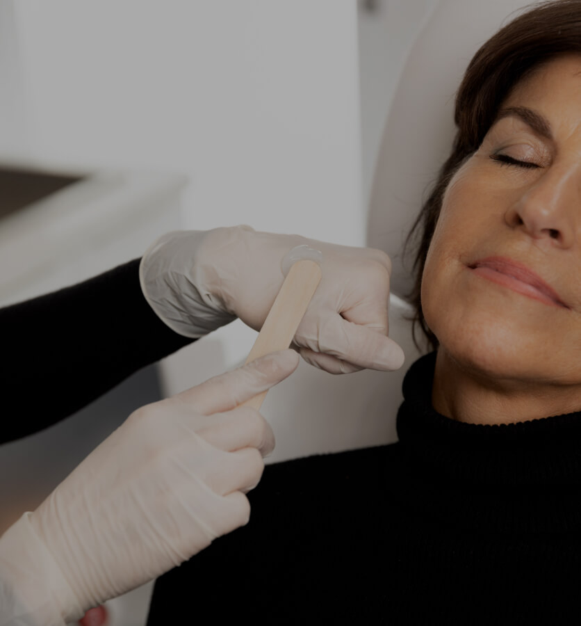 Une technicienne médico-esthétique de la Clinique Chloé appliquant du gel sur le visage d'une patiente