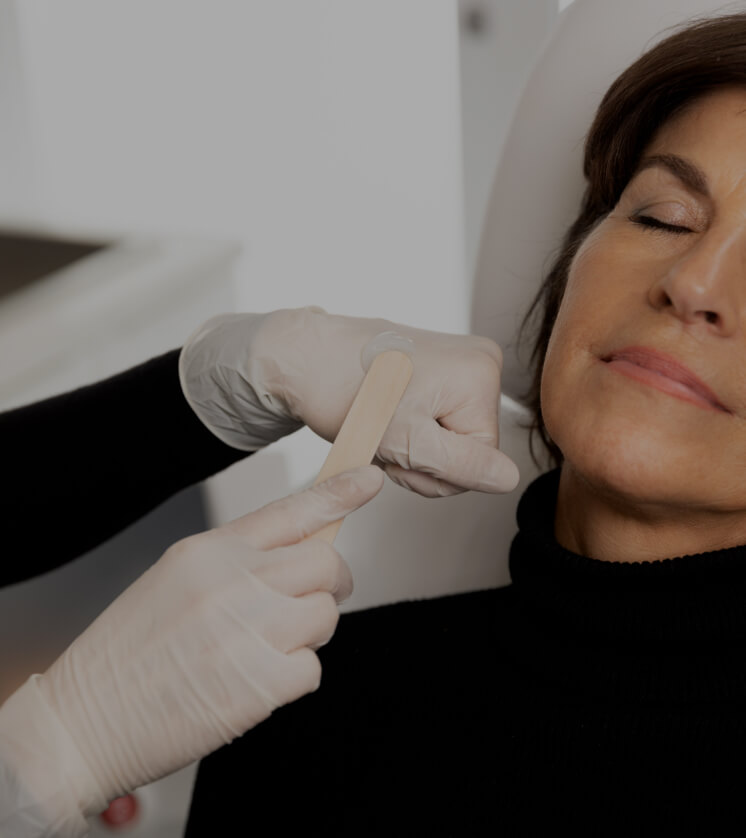 A medico-aesthetic technician from Clinique Chloé applying gel to the face of a patient before an IPL treatment