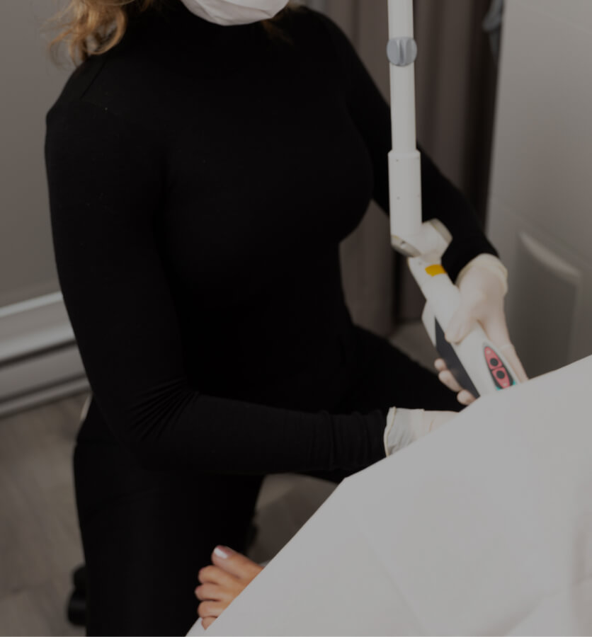 A nurse from Clinique Chloé sitting and inserting the RenovaLase laser handpiece into a patient's vagina