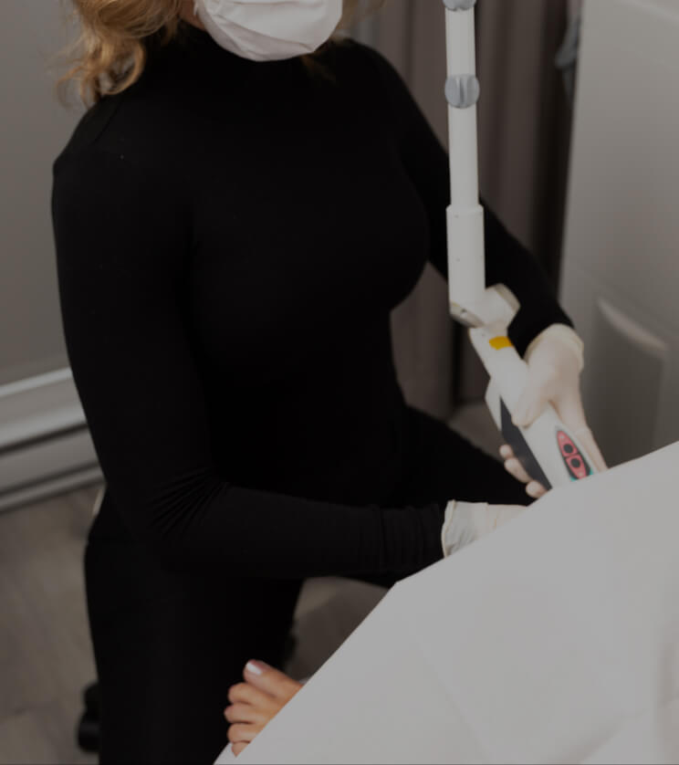 A nurse from Clinique Chloé sitting and inserting the RenovaLase laser handpiece into a patient's vagina