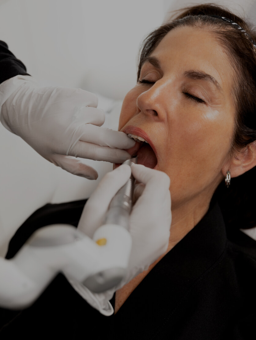 A medico-aesthetic technician at Clinique Chloé treating a female patient with the SmoothLiftin intraoral laser