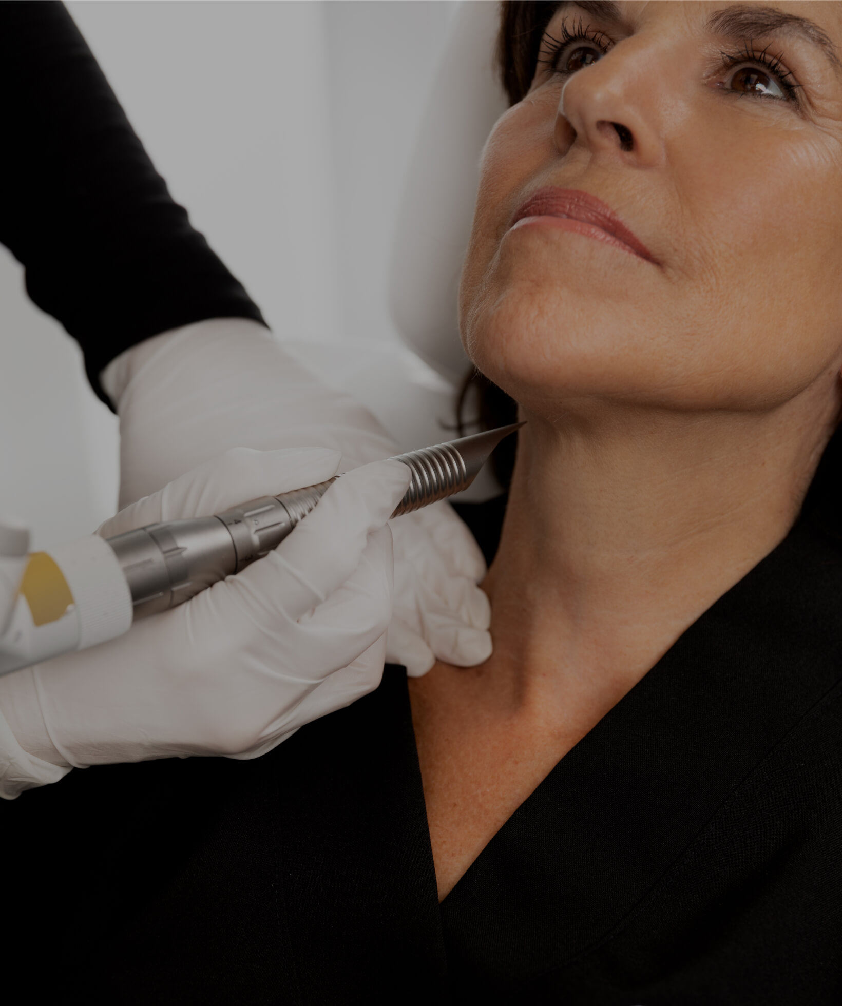 Une technicienne médico-esthétique de la Clinique Chloé traitant le cou d'une patiente avec le laser TightSculpting