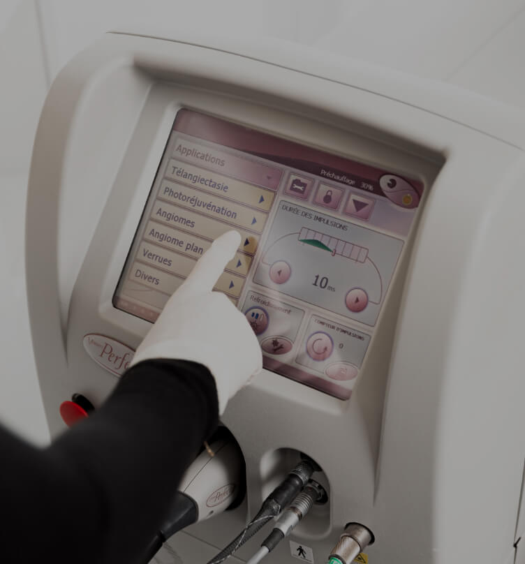 Une technicienne médico-esthétique de la Clinique Chloé ajustant des paramètres sur l'écran du laser Vbeam avec son doigt