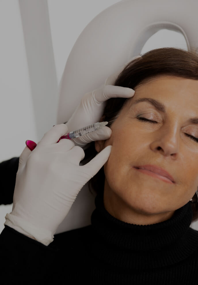 A doctor from Clinique Chloé performing a mesotherapy treatment on a patient's face