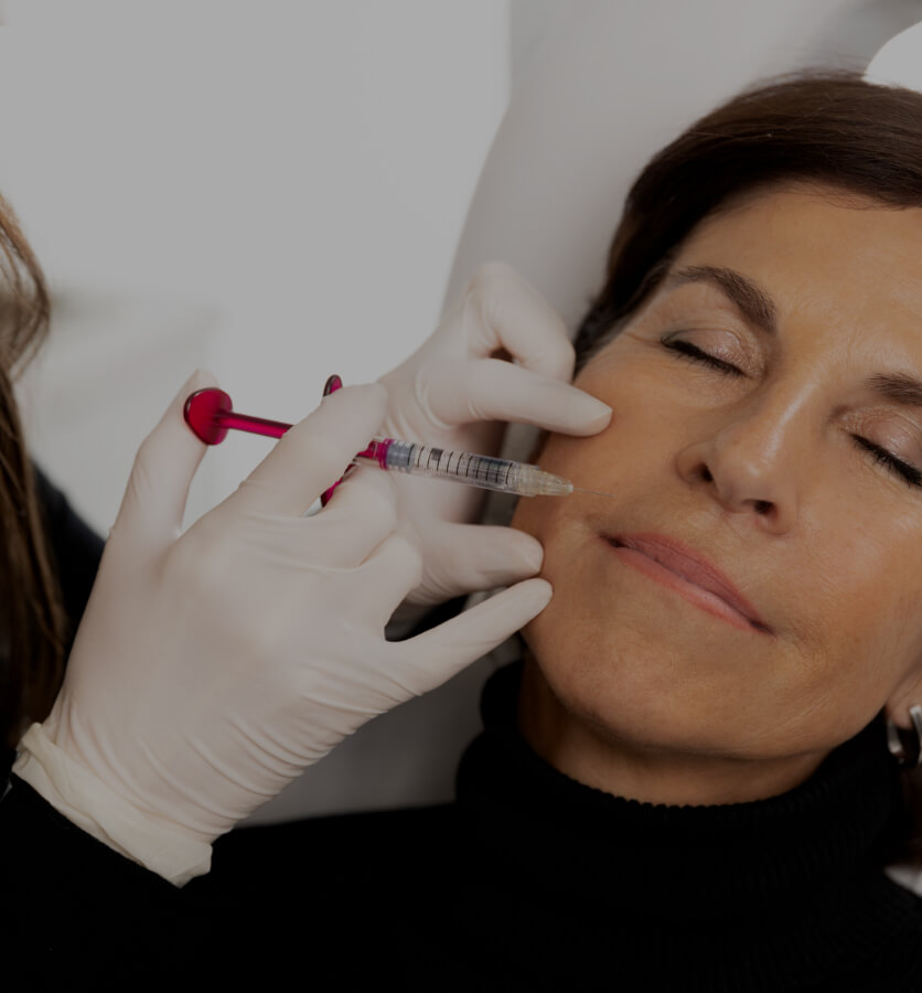 A doctor from Clinique Chloé performing a mesotherapy treatment on a female patient to reduce her nasolabial folds