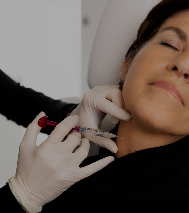 A doctor from Clinique Chloé performing a mesotherapy treatment on a patient's neck