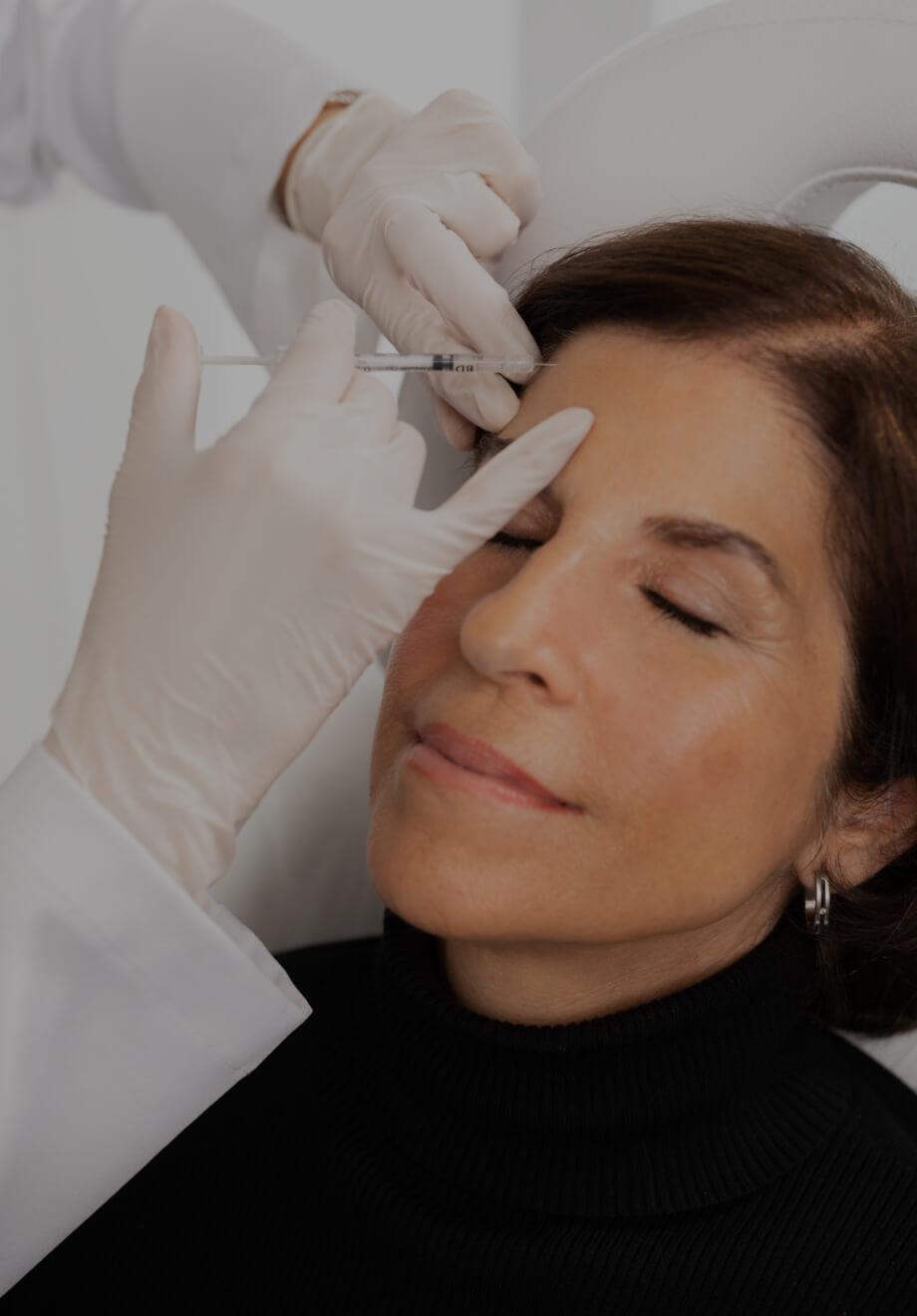 A doctor from Clinique Chloé performing neuromodulator injections into a patient's forehead
