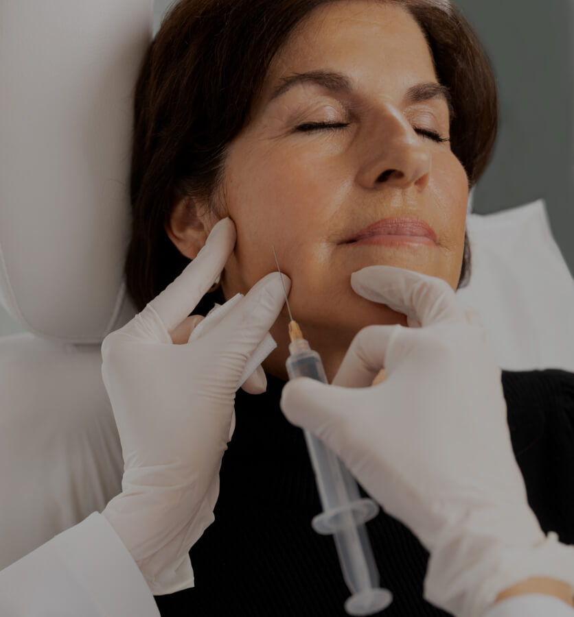 A doctor at Clinique Chloé performing Sculptra injections in a female patient's jawline