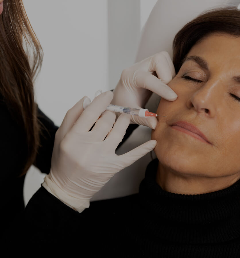 A doctor at Clinique Chloé doing Skinboosters injections into a patient's nasolabial folds