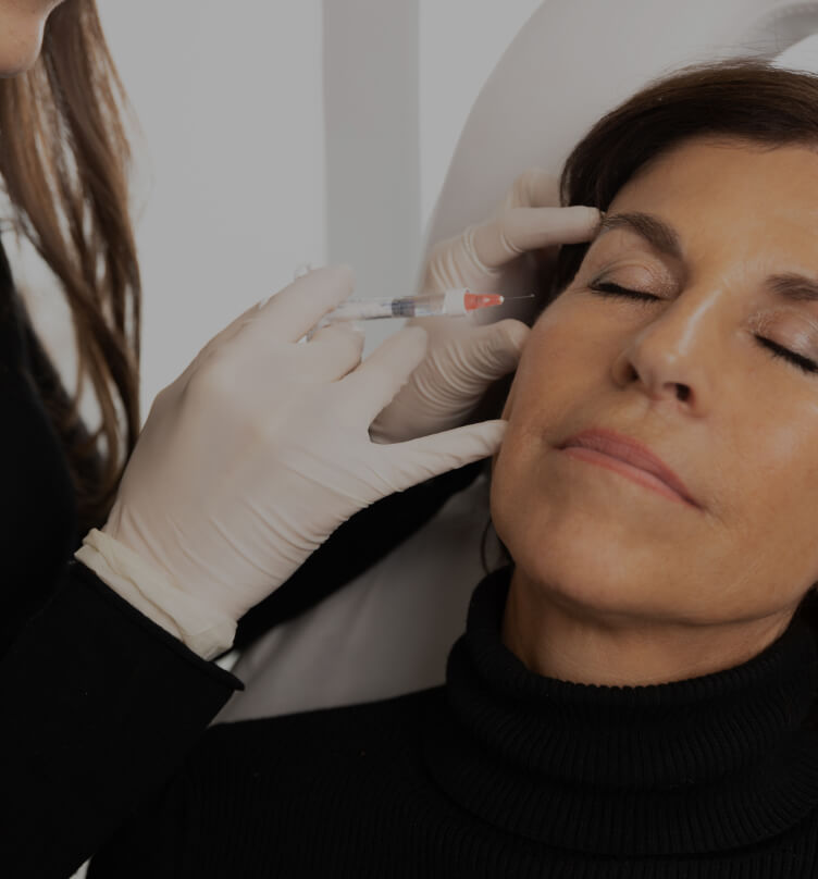 A doctor at Clinique Chloé doing Skinboosters injections into a patient's face