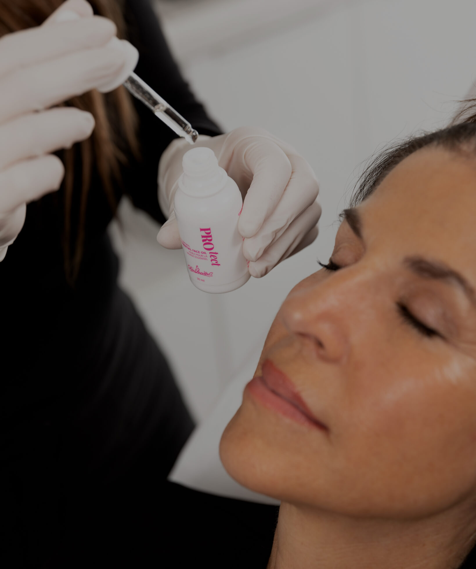 A Clinique Chloé medical aesthetic technician applying a serum to a female patient's face after a microneedling treatment